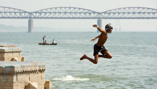 Varanasi, India: A boy jumps into the Ganges River for his bath