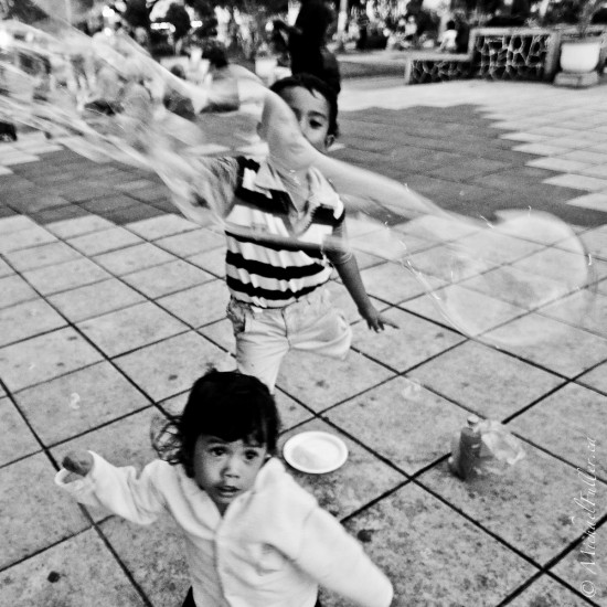 Two adorable kids playing in Bukittinggi's "Jam Gadang" (clock tower) square.