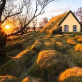 Using a narrow aperture to create a sunstar in a three image panorama, while the evening light highlights the raised graves at Hofskirkja. Nikon D810, 14–24mm at 14mm, ISO 100, 0.5s at f/22, tripod.