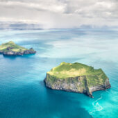 A rain squall moves along the mainland’s south coast with views of Bjarnarey and Elliðaey islands, as seen from a light aircraft. Nikon D850, 24–70mm at 50mm, ISO 200, 1/800s at f/8. CPL