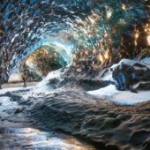 Sunlight filters down this large ice cave, creating hundreds of tiny sun stars as the ice refracts the light. Nikon D810, 24–70mm at 30mm, ISO 100, 15s at f/13, tripod